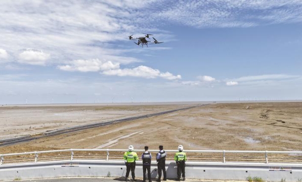 民警、輔警操控?zé)o人機(jī)在沿海灘涂巡防